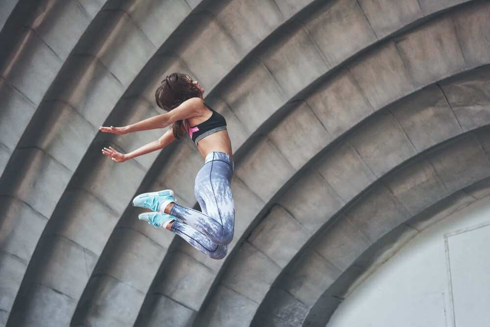 Photo of a beautiful woman doing parkour.