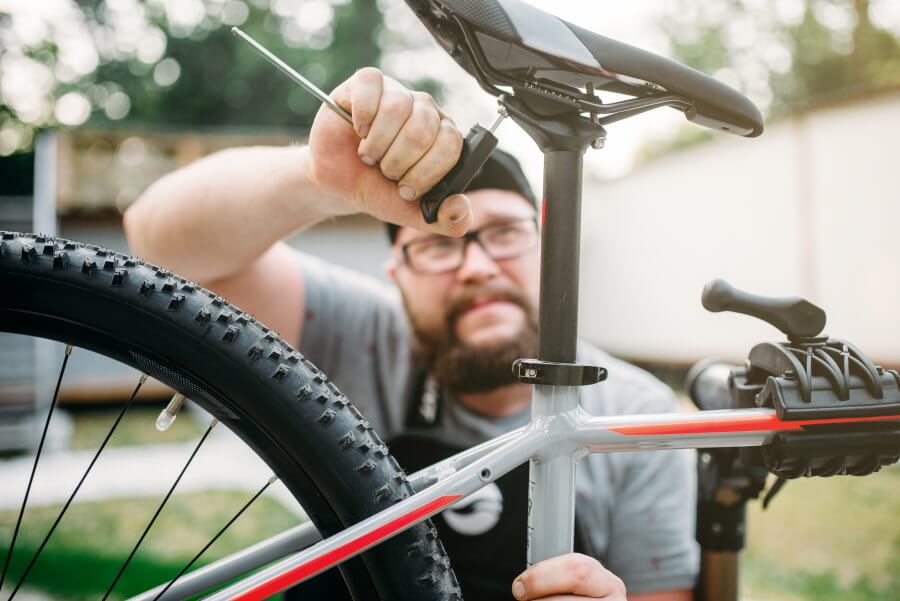 bicycle-mechanic-adjusts-with-tools-bike-seat-2021-08-26-16-25-52-utc